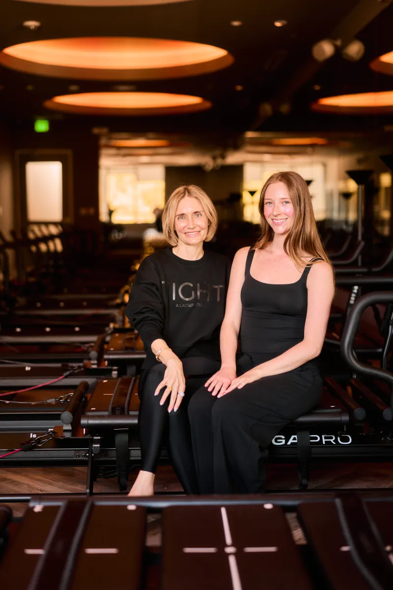 TIGHT Dallas owner Lita seated with a team member on a Megaformer in the Dallas studio