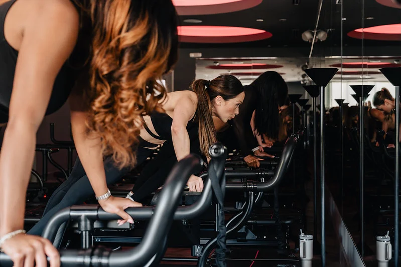 Close-up of clients in plank position on Megaformer machines at TIGHT Dallas
